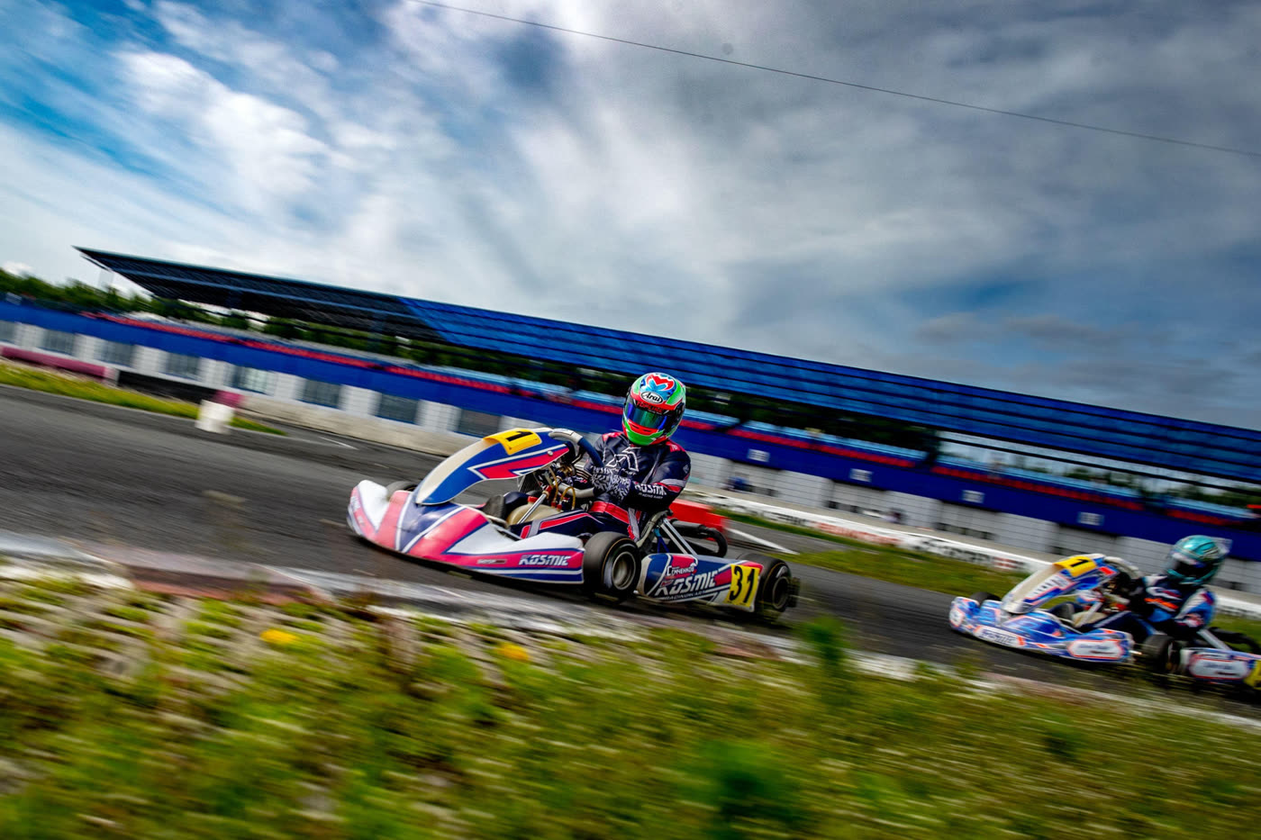 Two karts chasing down a straight under a dramatic sky